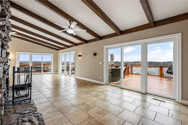 unfurnished living room with a healthy amount of sunlight, a water view, vaulted ceiling with beams, and ceiling fan