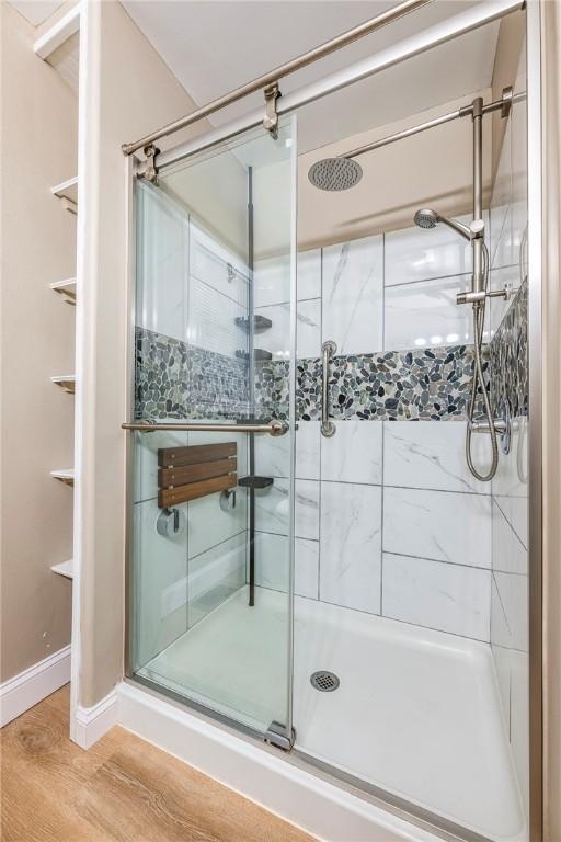 bathroom featuring wood-type flooring and an enclosed shower