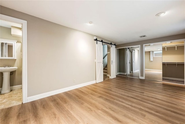 interior space with wood-type flooring and a barn door