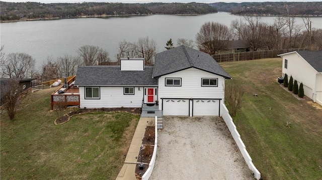 view of front of property with a garage, a water view, and a front yard