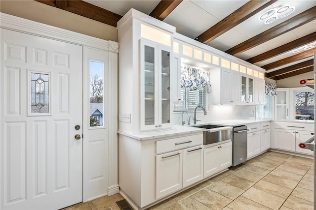 kitchen with white cabinetry, sink, light tile patterned floors, and vaulted ceiling with beams