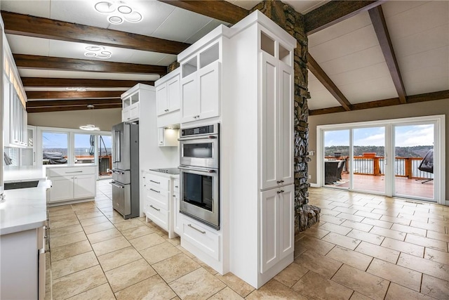 kitchen with white cabinetry, vaulted ceiling with beams, a wealth of natural light, and stainless steel appliances