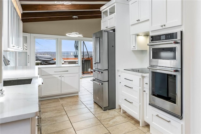 kitchen with white cabinetry, light stone counters, stainless steel appliances, and decorative light fixtures