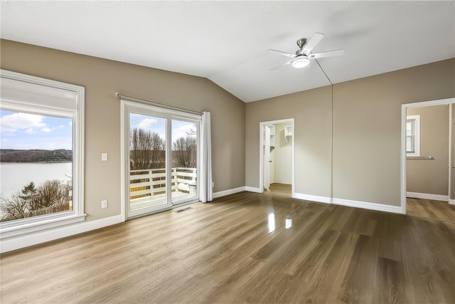 interior space with ceiling fan, wood-type flooring, a healthy amount of sunlight, and vaulted ceiling