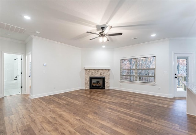 unfurnished living room featuring crown molding, ceiling fan, hardwood / wood-style floors, and a tile fireplace