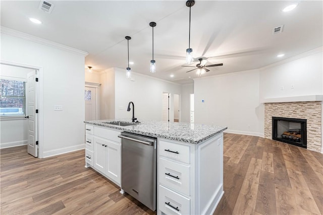 kitchen with sink, dishwasher, white cabinetry, light stone countertops, and an island with sink