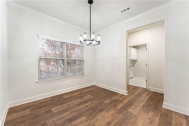 unfurnished dining area featuring dark hardwood / wood-style flooring, ornamental molding, and an inviting chandelier