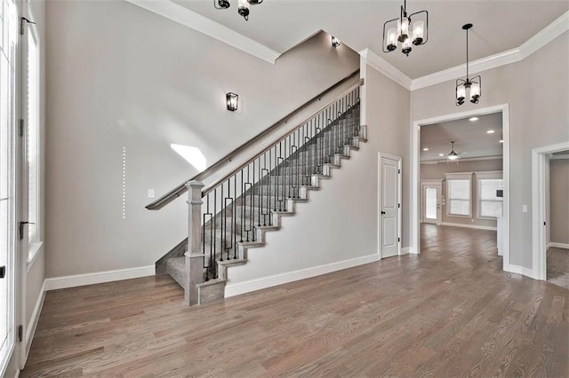 entryway featuring ceiling fan, ornamental molding, and wood-type flooring