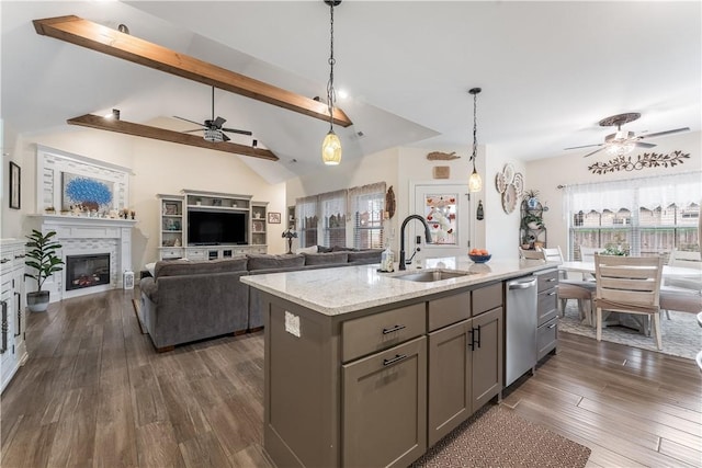 kitchen featuring gray cabinets, pendant lighting, an island with sink, sink, and light stone counters