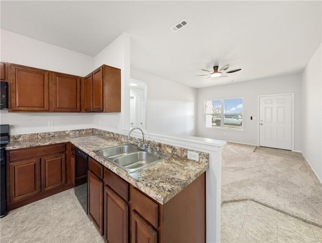 kitchen with black appliances, sink, light colored carpet, ceiling fan, and kitchen peninsula