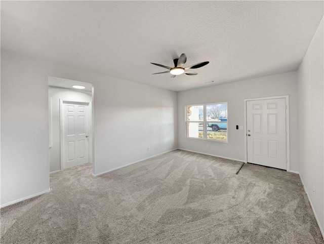 carpeted spare room featuring ceiling fan and a textured ceiling