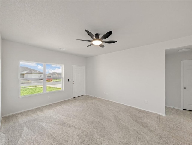 carpeted spare room with ceiling fan