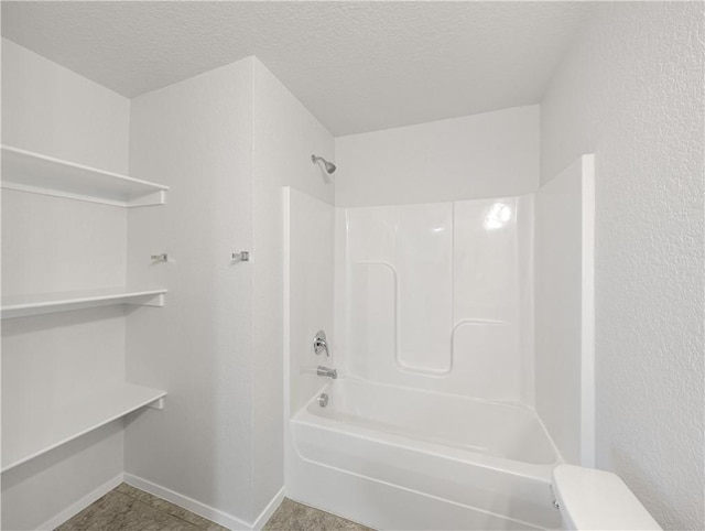 bathroom with bathtub / shower combination and a textured ceiling