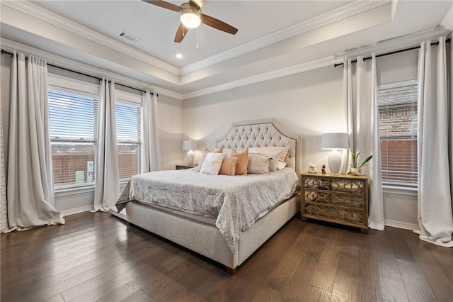 bedroom featuring crown molding, ceiling fan, dark hardwood / wood-style flooring, and a tray ceiling