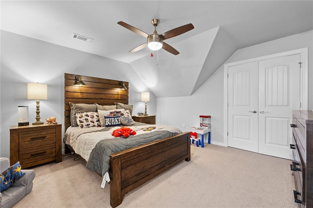 carpeted bedroom featuring ceiling fan, vaulted ceiling, and a closet