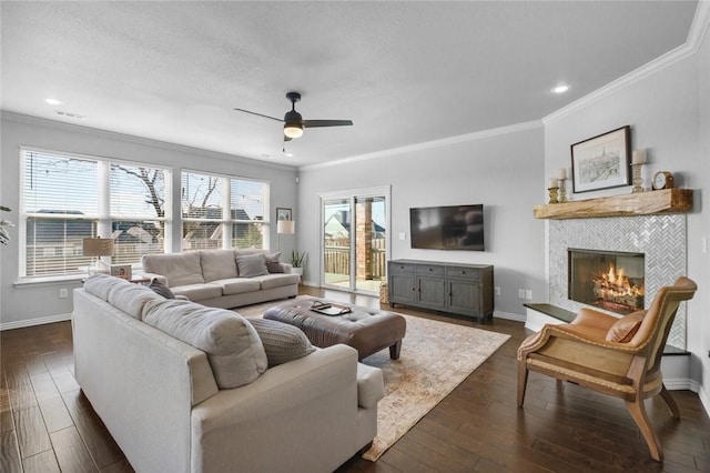 living room featuring a tile fireplace, crown molding, ceiling fan, and dark hardwood / wood-style flooring