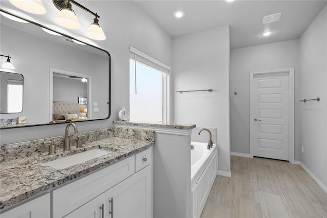 bathroom with a tub to relax in and vanity