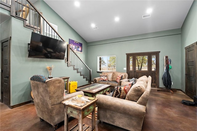 living area featuring stairway, baseboards, visible vents, and concrete floors