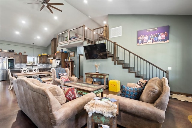 living room with stairway, high vaulted ceiling, visible vents, and finished concrete floors