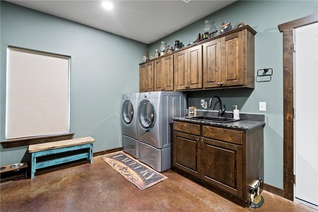 laundry area featuring washer and clothes dryer, a sink, cabinet space, and baseboards