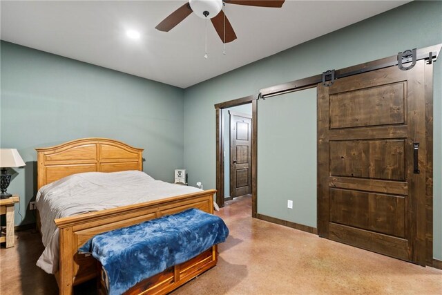 bedroom featuring a barn door, baseboards, and ceiling fan