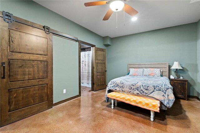 bedroom featuring a barn door, baseboards, and ceiling fan