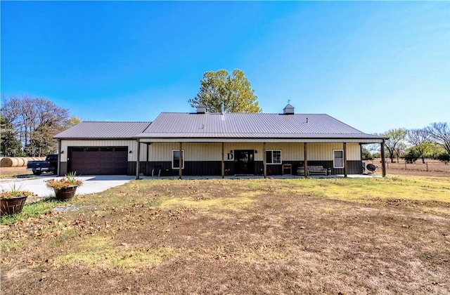 view of front of house featuring a garage, metal roof, and driveway