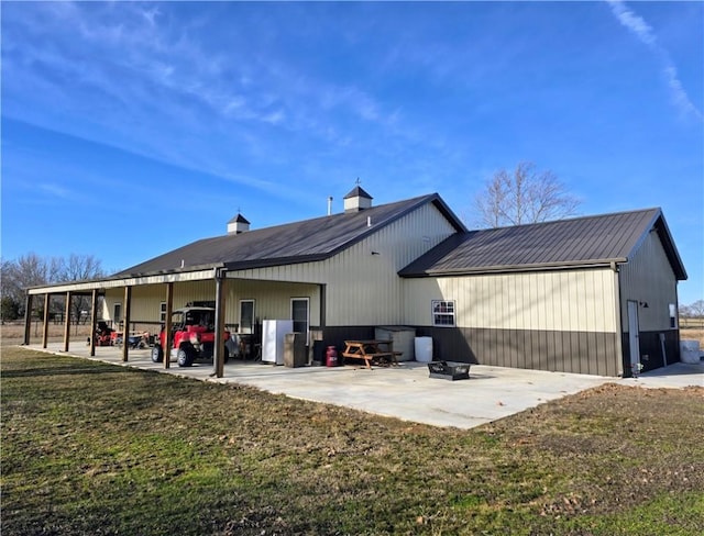 rear view of house featuring a lawn and a patio area