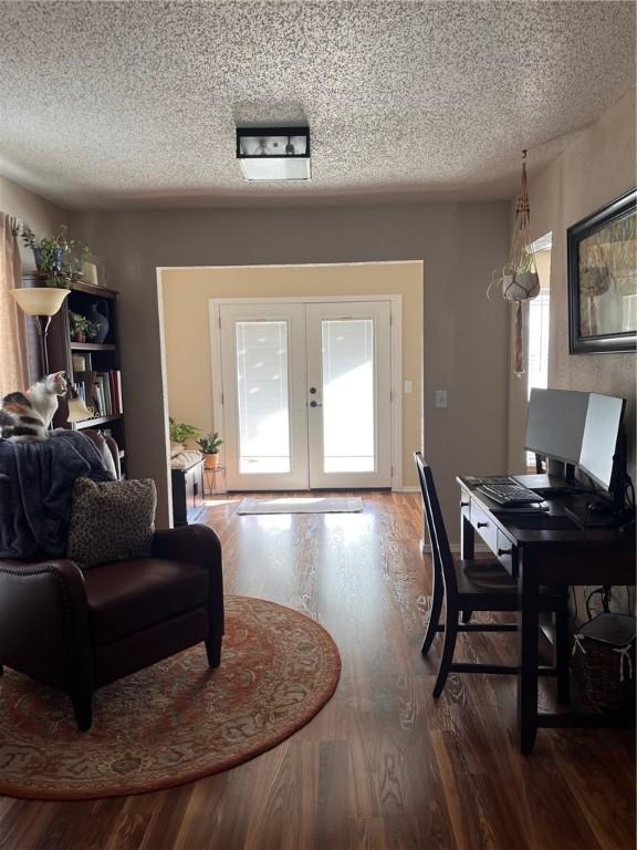 interior space featuring a textured ceiling, wood finished floors, and french doors