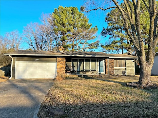 ranch-style home featuring a garage and a front lawn