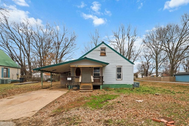 view of front of house featuring a carport, covered porch, and central air condition unit