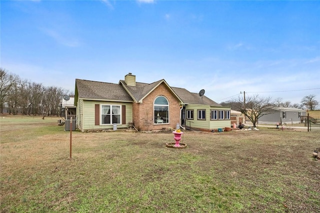 view of front of home with a front yard and central air condition unit