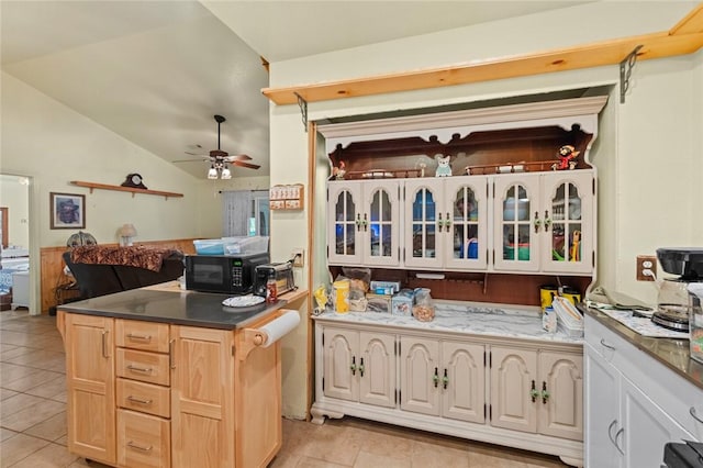 kitchen featuring light brown cabinetry, vaulted ceiling, light tile patterned floors, kitchen peninsula, and ceiling fan