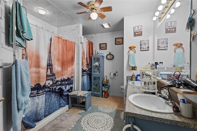 bathroom featuring ceiling fan, a shower with shower curtain, vanity, tile patterned floors, and toilet