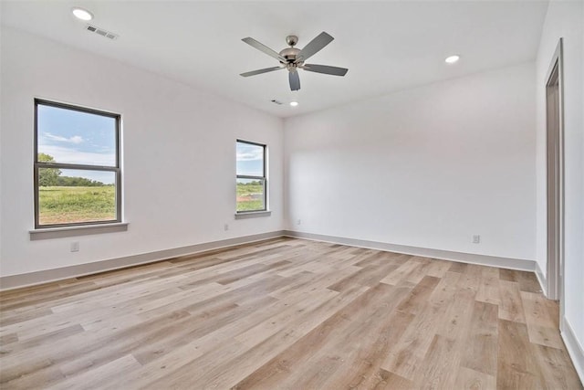 empty room with ceiling fan and light hardwood / wood-style flooring