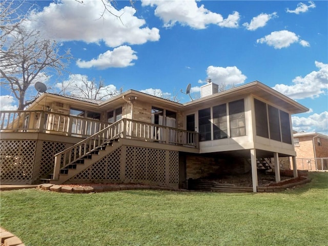 rear view of house with a lawn, a sunroom, a chimney, stairway, and a wooden deck