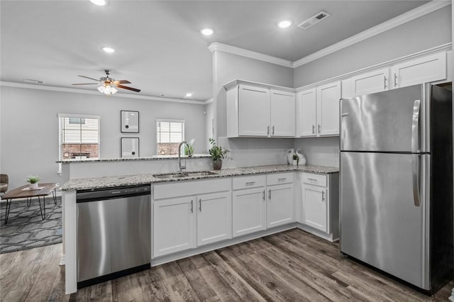 2643 S Kilimanjaro Way, Rogers, AR 72758 - kitchen with appliances with stainless steel finishes, crown molding, white cabinetry, a peninsula, and light stone countertops