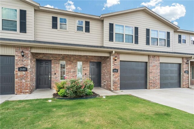 2682 W Kilimanjaro Way, Rogers, AR 72758 - view of property with concrete driveway, an attached garage, brick siding, and a front lawn