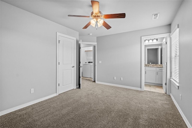 unfurnished bedroom with ensuite bathroom, washer / dryer, light carpet, and ceiling fan