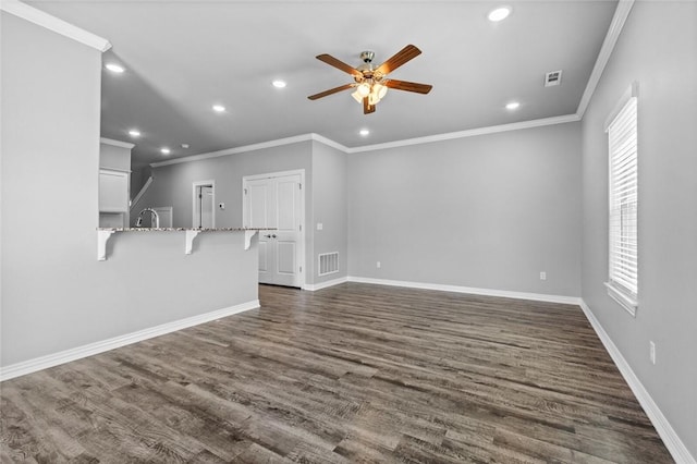 unfurnished living room featuring ornamental molding, plenty of natural light, and dark hardwood / wood-style flooring