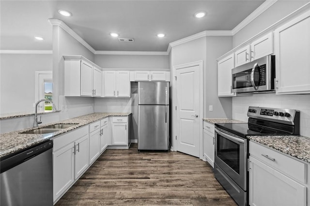 2633 S Kilimanjaro Way, Rogers, AR 72758 - kitchen with appliances with stainless steel finishes, white cabinetry, ornamental molding, dark wood finished floors, and light stone counters