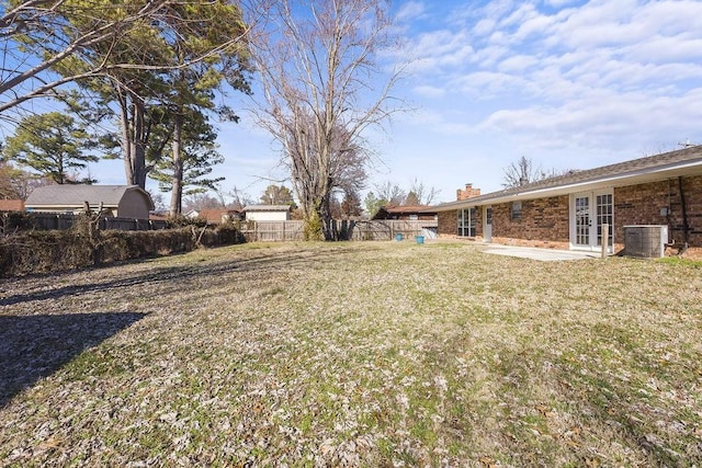 view of yard featuring a patio, central AC unit, and french doors