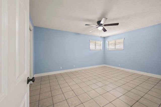 spare room with ceiling fan and baseboards