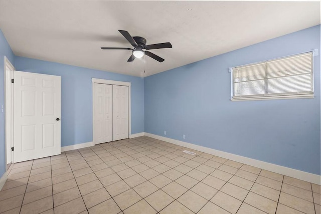 unfurnished bedroom with a closet, baseboards, and ceiling fan