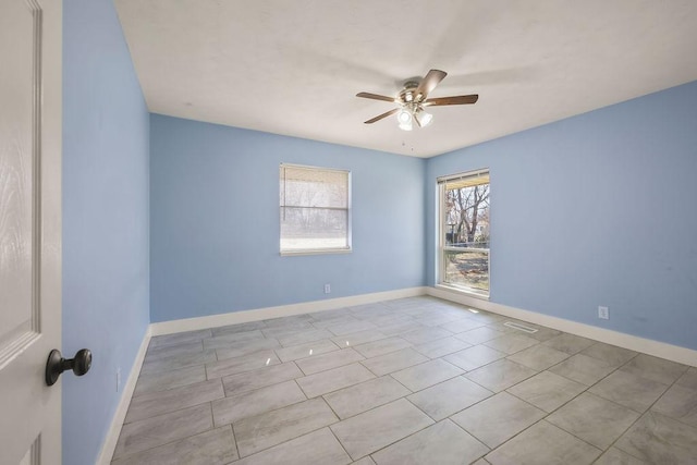 unfurnished room featuring ceiling fan and baseboards