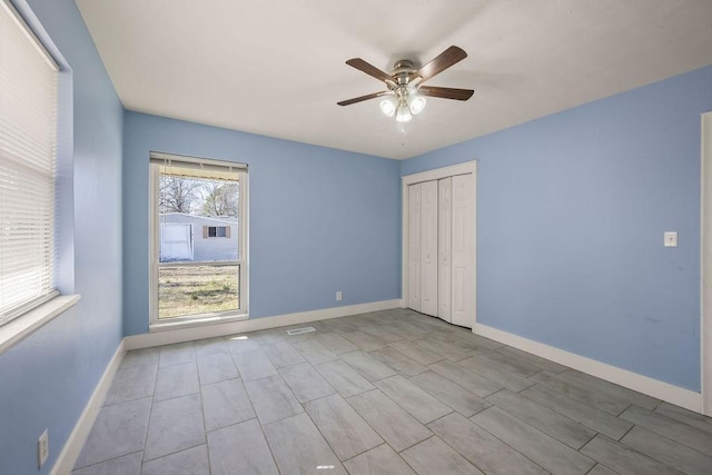 unfurnished bedroom featuring a closet, baseboards, and a ceiling fan