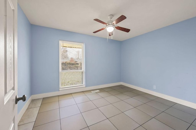 spare room featuring ceiling fan, baseboards, and light tile patterned flooring