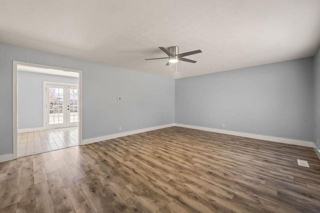 unfurnished room featuring wood finished floors, french doors, a ceiling fan, and baseboards