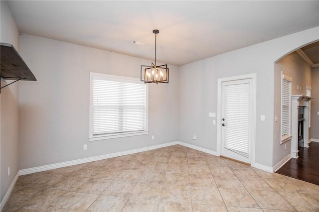 tiled empty room with a notable chandelier