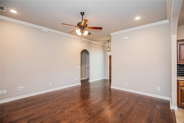 empty room featuring dark hardwood / wood-style flooring, crown molding, and ceiling fan